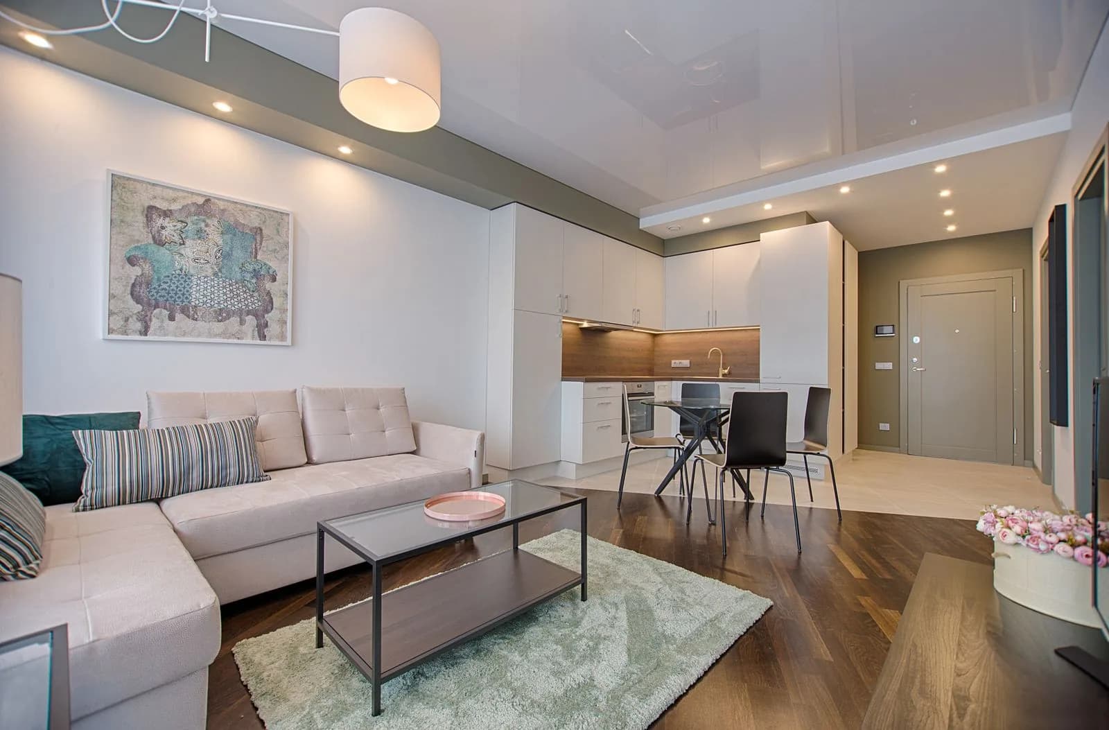 Bright living room with a sofa, rug, and open kitchen